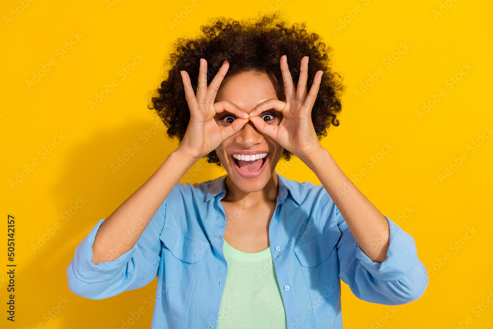 Photo of funky nice crazy lady look adventure fingers binoculars wear jeans shirt isolated yellow color background Photo of funky nice crazy lady look adventure fingers binoculars wear jeans shirt isolated yellow color background