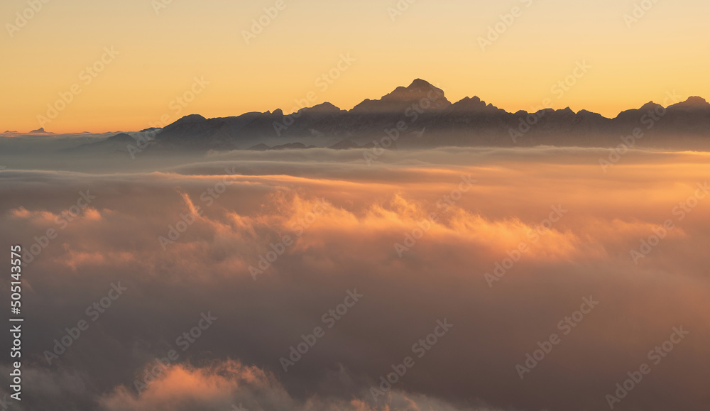 Vivid and foggy sunset from the top of the mountains in the Alps