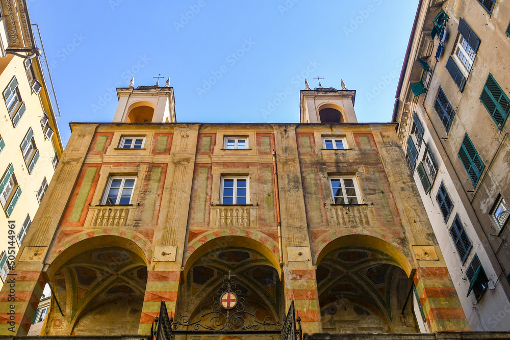 Low-angle view of the Church of San Pietro in Banchi (1572) with frescoed porch and two small bell towers against clear blue sky, Genoa, Liguria, Italy