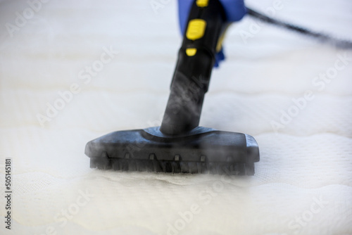Cleaning and disinfection of the mattress in the bedroom with hot steam. Professional cleaning process