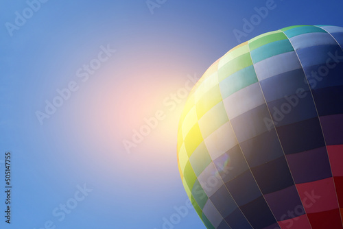Colorful hot air balloon in flight against the blue sky.