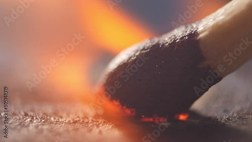 Extreme close up of a match lights in slow motion. Macro shot of a matchbox. Slow burning with sparks and smoke. Microscope view