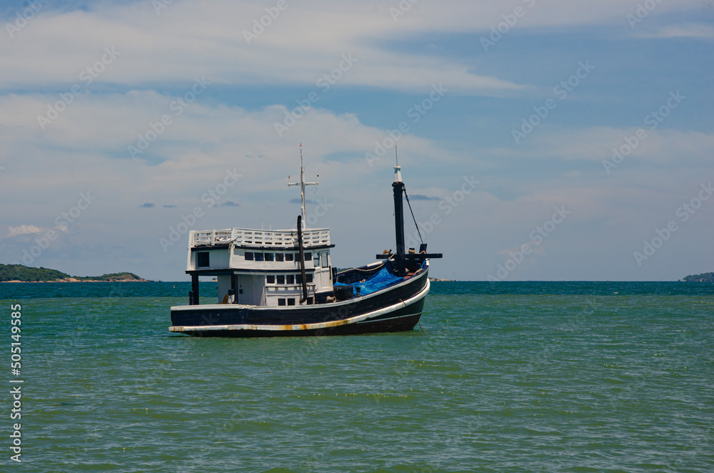 Old black and white fisherman boat floats in the sea Old black and white fisherman boat floats in the sea