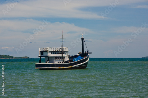 Old black and white fisherman boat floats in the sea