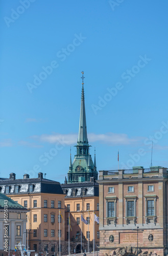 Facades of buildings and the castle in the island Gamla Stan and the spire of the german church a sunny day in Stockholm