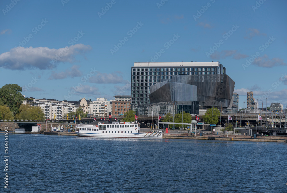 Obraz premium Pier with old steam commuting boat and the modern convention house Stockholm Waterfront a sunny day in Stockholm