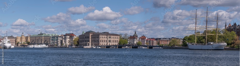 Panorama view over the bay Strömmen with commuting ferries, boats, museums and offices a sunny day in Stockholm