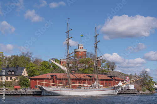 Fototapeta Harbor view with a castle, old coal shed and the brig Tre Kronor on the island K