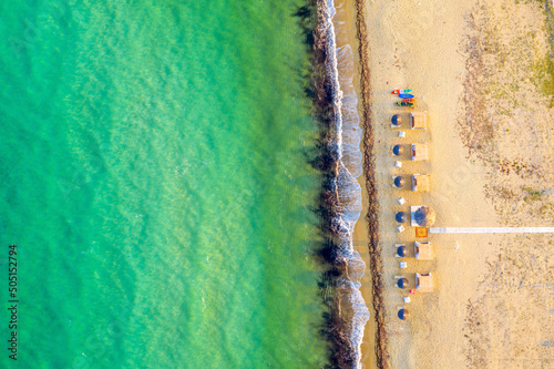 Obraz na płótnie Aerial view of sea and sand beach on a sunny day. Top view Sandy coastline with white turquiose sea waves. Summer sunset seascape... w salonie