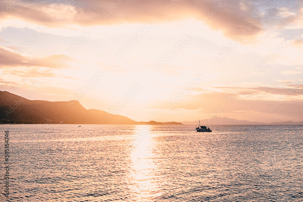 Photographs of beaches of Margarita Nueva Esparta in the morning and at sunset. You can see mountains, sun, clouds, sun rays, sunset, beaches, ships, boats, people fishing, rocks, waves, mist,