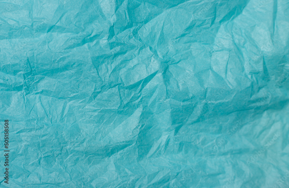 The texture of crumpled blue paper. Paper for wrapping gifts and flowers. Abstract background made of tishyu paper. The texture of crumpled blue paper. Paper for wrapping gifts and flowers. Abstract background made of tishyu paper.