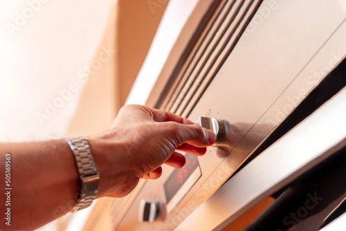 Man's hand using oven controls for food preparation © javidestock