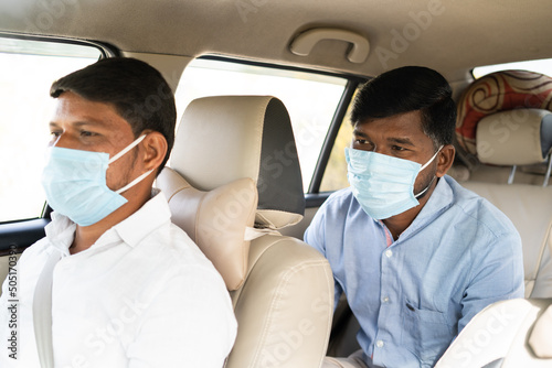passanger with Taxi driver talking about destination while both in mask due coronavirus pandemic - concept of traveling with covid safely precautions, back to business and pollution
