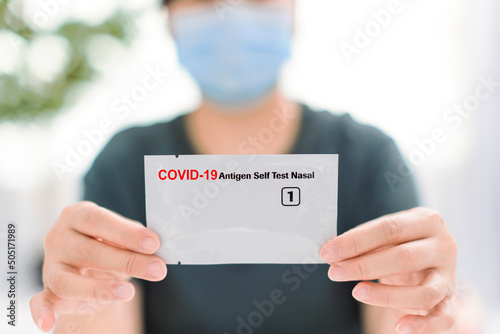 Woman showing  COVID-19 home self test kit