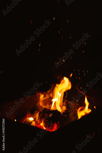 burning firewood in the brazier at night, flames of fire in the dark photo