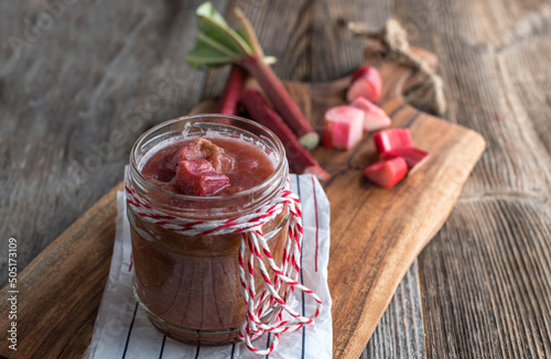 Homemade rhubarb compote on wooden table photo