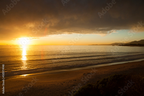 Winter sunset with golden light under heavy storm clouds. Looking out to the Pacific ocean near Ventura  California  USA