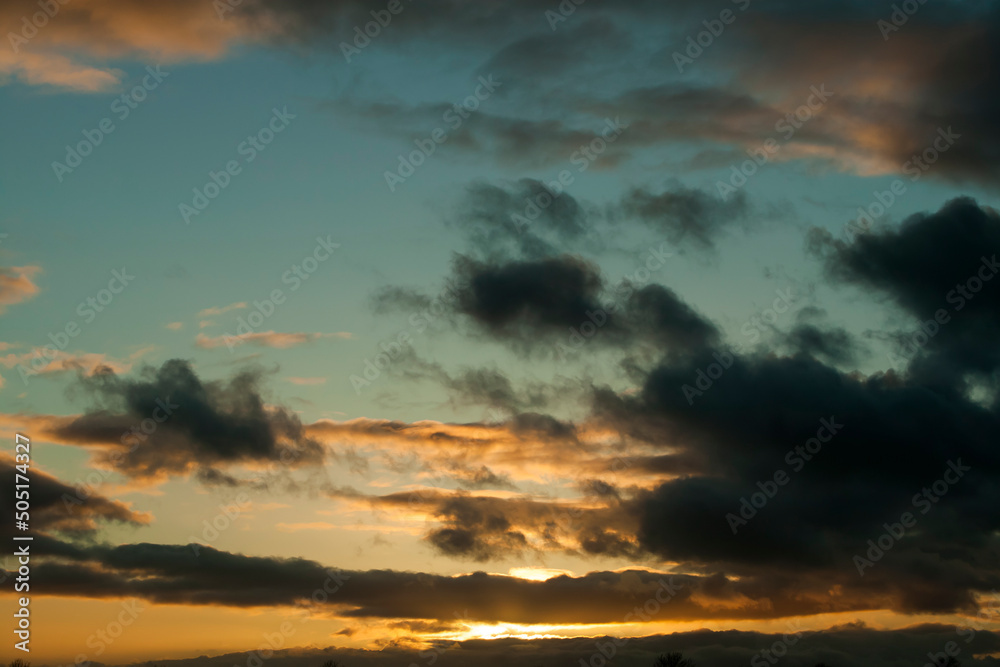 Sunset in springtime with golden light and stormy looking stratocumulus clouds. Kildare, Ireland