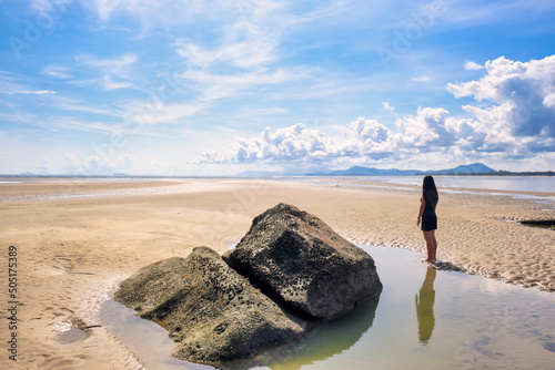Fotografie Solo woman traveler standing alone on a deserted beach