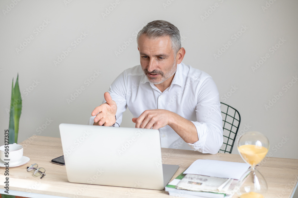 Man talking on video call looking at laptop Man talking on video call looking at laptop