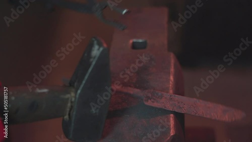 Blacksmith manually forging molten metal in smithy workshop. Damascus steel knife.