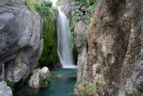 A waterfall with a silky effect at the bottom of a canyon photo