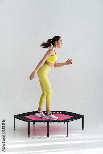 young fitness woman In sportswear jumping on sport trampoline
