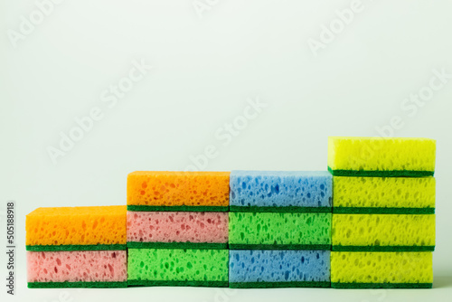 stack of porous multicolored sponge scourers on grey background. photo