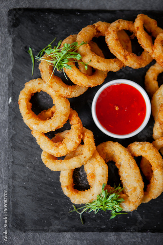 onion rings appetizer to beer on a black board