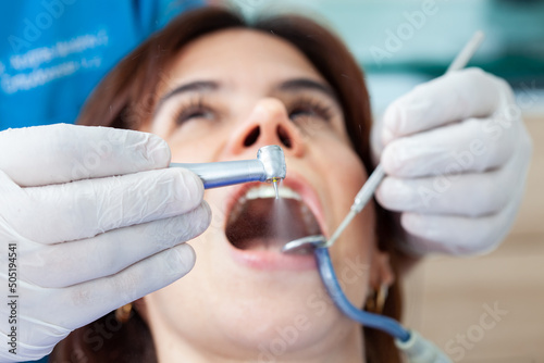 Closeup of a dental bur being used by the dentist during a dental treatment for a beautiful woman.