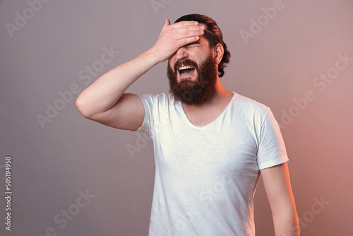 Bild auf Leinwand Distraught bearded man is giving himself a facepalm as he forgot something