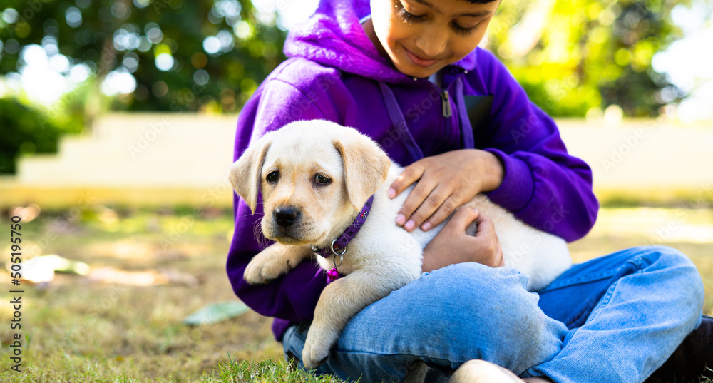Close up of Young Kid playing holding puppy dog at park - concpet companion, friends and recreation. Close up of Young Kid playing holding puppy dog at park - concpet companion, friends and recreation.