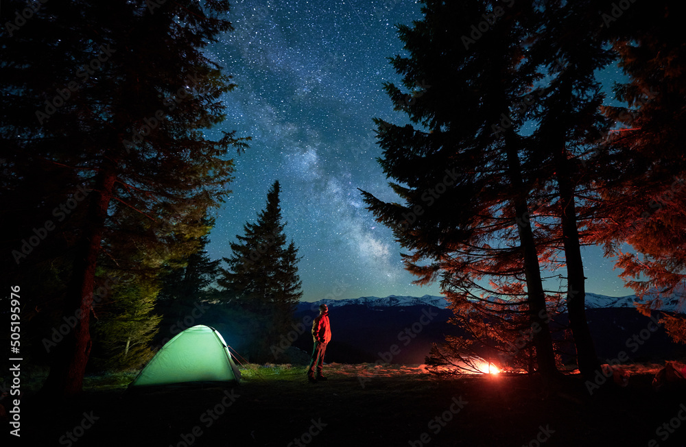 Fototapet Side view of male hiker looking up admire beauty of picturesque starry sky with