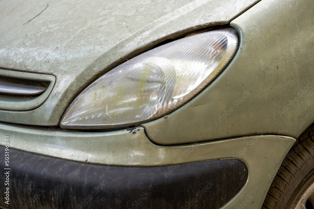 Closeup of headlights of an abandoned car