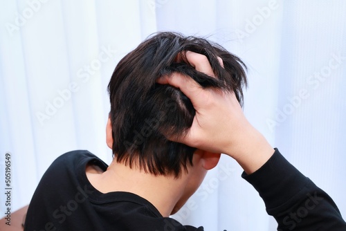 人生の悩みを抱える男性の後頭部