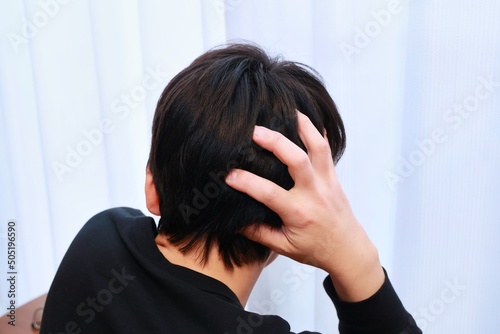 人生の悩みを抱える男性の後頭部