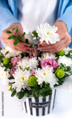 The florist woman makes a beautiful birthday bouquet. Close-up. Selective focus.