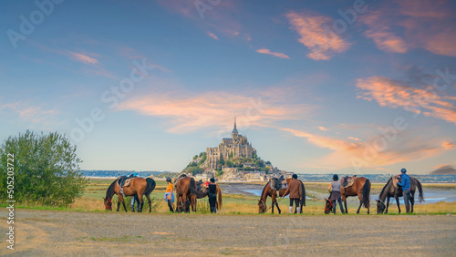 Obraz na płótnie Horses and tourists with famous Le Mont Saint-Michel in Normandy, northern Franc