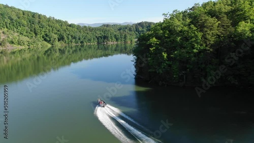 Aerial tracking motor boat in Fontana lake in Smoky Mountains, North Carolina and reveal to railroad trestle bridge photo