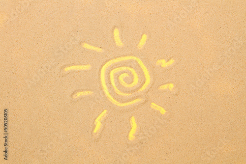 Sol dibujado sobre un fondo de arena. Vista superior y de cerca. Copy space. Concepto: Verano