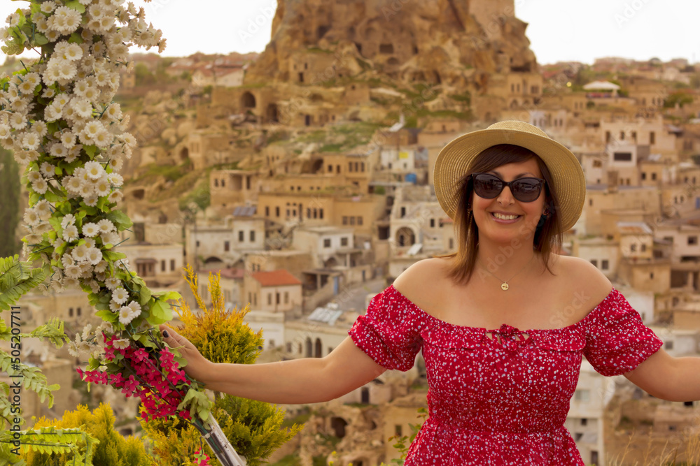 beautiful woman in a hat on the terrace in cappadocia, turkey