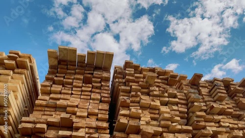 Wooden boards, lumber, industrial wood, timber. Pine wood timber stack of natural rough wooden boards on building site. Industrial timber building materials photo