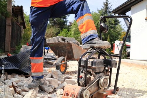 Construction. The foreman at the construction site puts his foot on the compactor. Budowa. Brygadzista na budowie stawia stopę na zagęszczarce. 