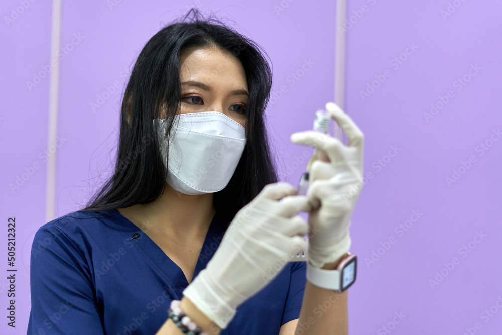 Serious doctor preparing a vaccine of collagen for a rejuvenation treatment