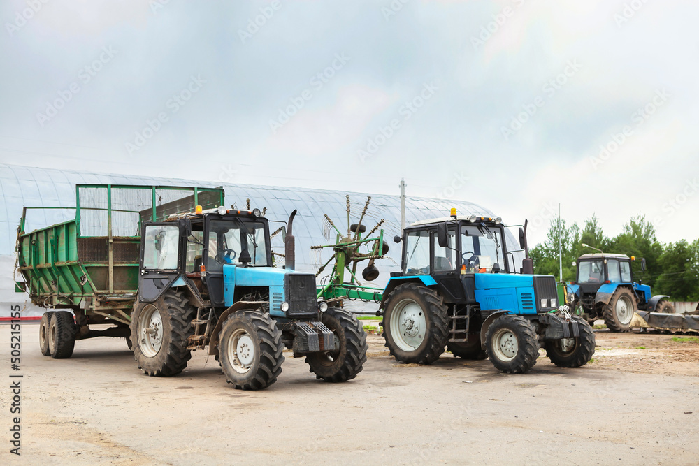 Blue tractor with equipment for turning and drying hay, ready to work in the field. Blue tractor with equipment for turning and drying hay, ready to work in the field.
