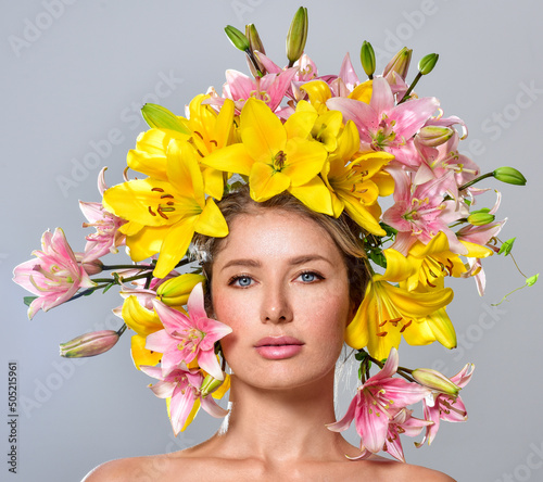 Beautiful woman with flowers in her hair. Bouquet of Beautiful Flowers. Hairstyle with flowers. Nature Hairstyle. Multicolored lilies