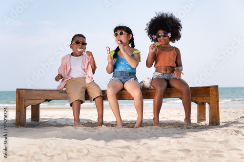 Wall Mural Happy fun boy and girl kids eat ice cream on the beach