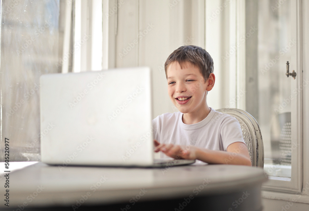young boy uses a notebook at home young boy uses a notebook at home