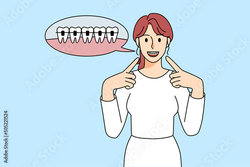 Happy woman point at dental braces on teeth 