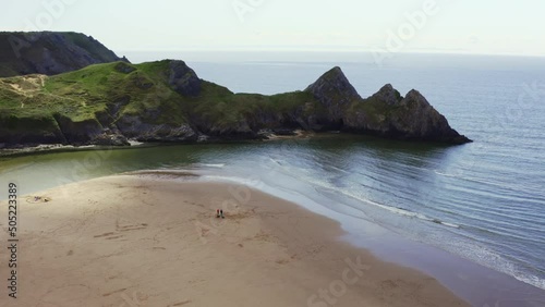 Aerial drone view flying around three cliffs at high tide. Three Cliffs Bay, Gower, Wales photo